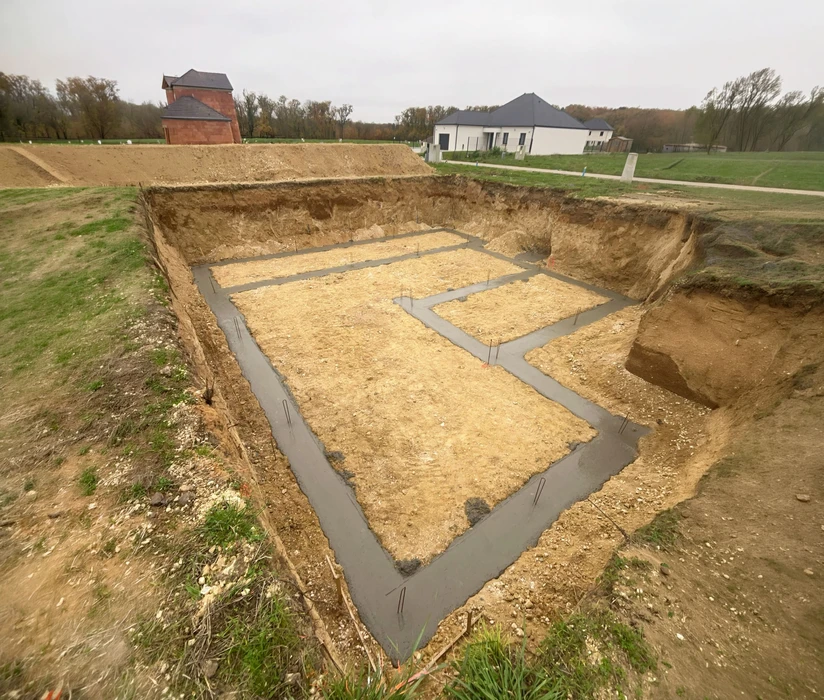 Façade de maison traditionnelle en briques rouges avec volets battants gris anthracite, porte d'entrée assortie et fenêtres à persiennes