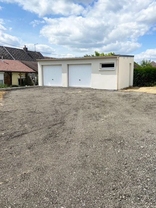 Construction de maison individuelle en cours, murs en briques bio'bric orange sur fondations béton