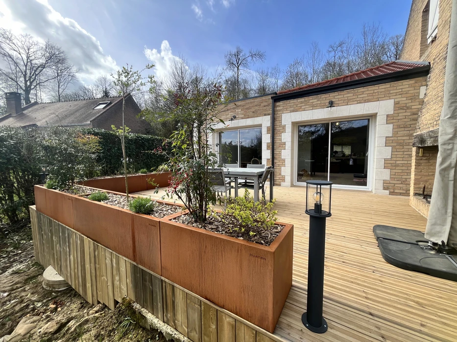 Cuisine extérieure couverte avec îlot central en pierre naturelle, plan de travail en quartz blanc, façade laquée blanche
